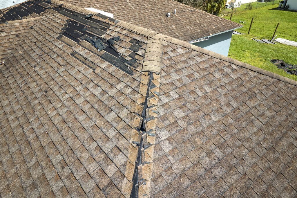 A home with damaged shingles displaying one of the main signs you need a new roof